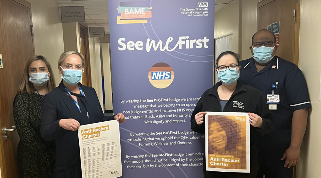Four people hold copies of the Anti-Racism Charter at the Queen Elizabeth Hospital Kings Lynn