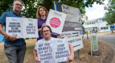 People hold placards protesting against parking charges at Broomfield Hospital