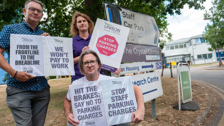 People hold placards protesting against parking charges at Broomfield Hospital