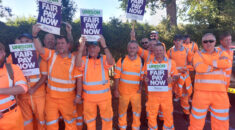 Refuse workers hold signs reading: 'Fair pay now'