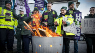 UNISON members stand around a brazier on the picket line