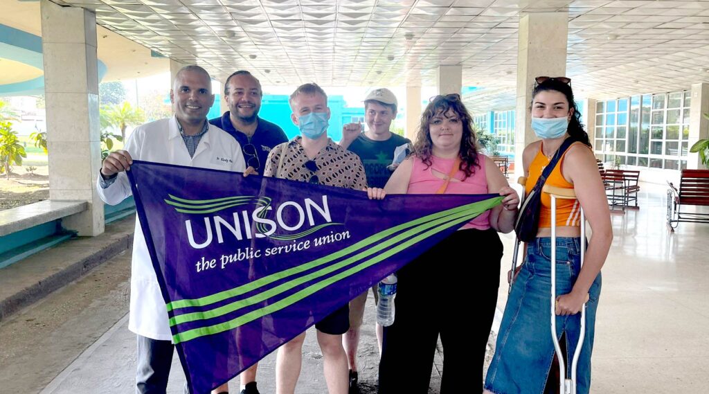 Members of the brigade visit a hospital where they hold a UNISON flag with a doctor