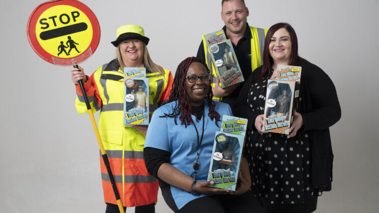 Four local government heroes hold action figure versions of themselves dressed in the same uniform: a lollipop lady, a care worker, a refuse worker and a librarian