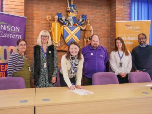St Albans chief executive Amanda Foley signs the charter flanked by UNISON activists