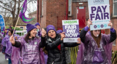 Strikers hold placards calling for fair pay for patient care
