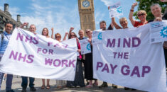 Mind counsellors stand outside the Houses of Parliament with banners reading 'NHS pay for NHS work' and 'Mind the pay gap'