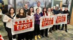 Young workers pose with EPSU flags