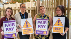 School support staff hold signs calling for fair pay and reading "Lift: out of order"
