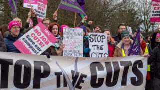 People hold signs opposing cuts at the University of Essex